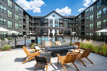 an outdoor patio area with a fire pit and chairs